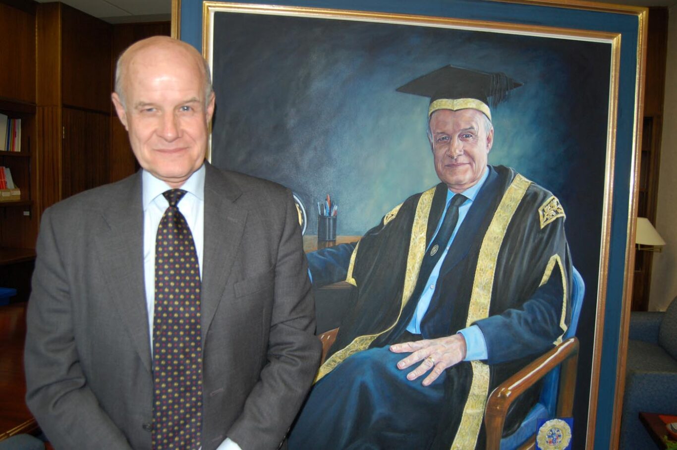 Professor Chris Taylor with his portrait at Bradford University